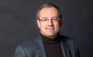 Eutelsat CEO Jean-François Fallacher is pictured in a suit, against a grey background.